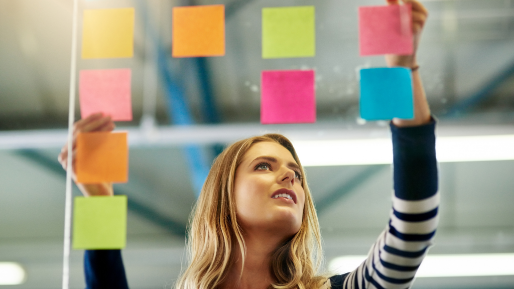 Uma mulher manuseando pequenos post-its.