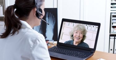 Uma mulher realizando uma teleconsulta com uma médica.