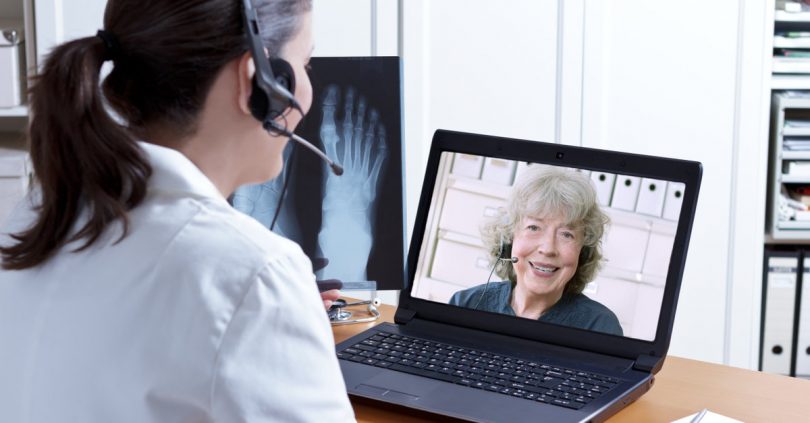 Uma mulher realizando uma teleconsulta com uma médica.