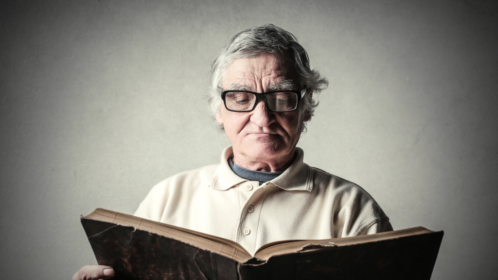 Um homem idoso lendo um livro.