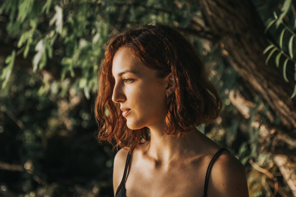 Garota de cabelo curto olhando para frente com semblante indiferente.