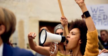 Mulher negra protestando com mega fone