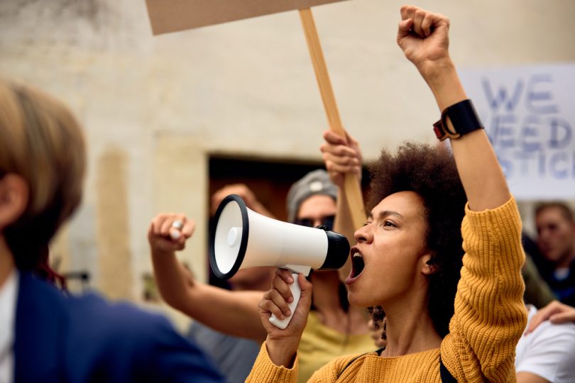 Mulher negra protestando com mega fone