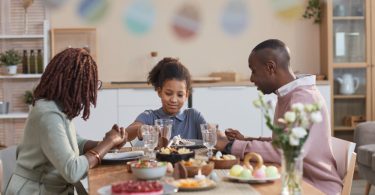 Família sentada à mesa durante um almoço farto