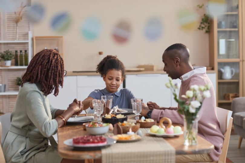 Família sentada à mesa durante um almoço farto