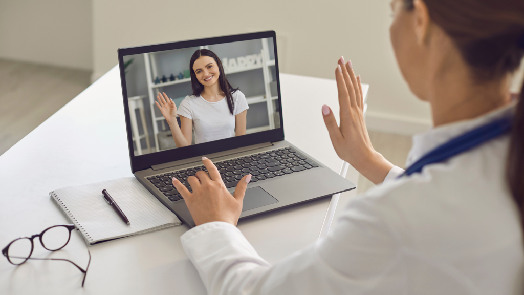 Uma médica e uma mulher realizando uma teleconsulta via internet.