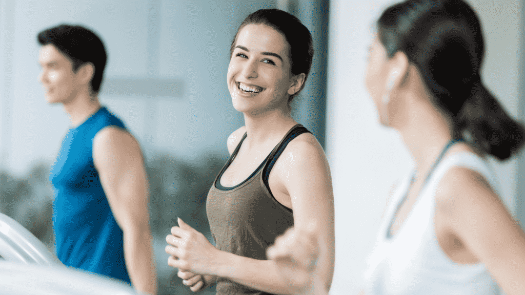 Duas amigas fazendo exercícios em uma esteira enquanto conversam