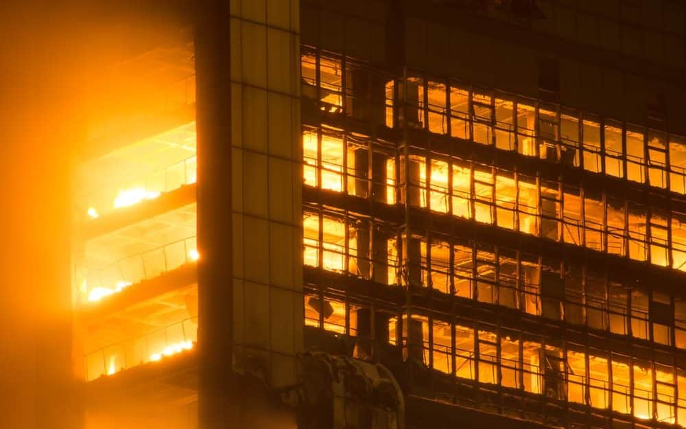 Fogo invadindo o interior de um prédio.