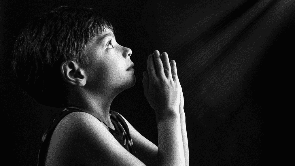 Um garoto orando.