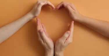 Mãos de pessoas formando um coração.