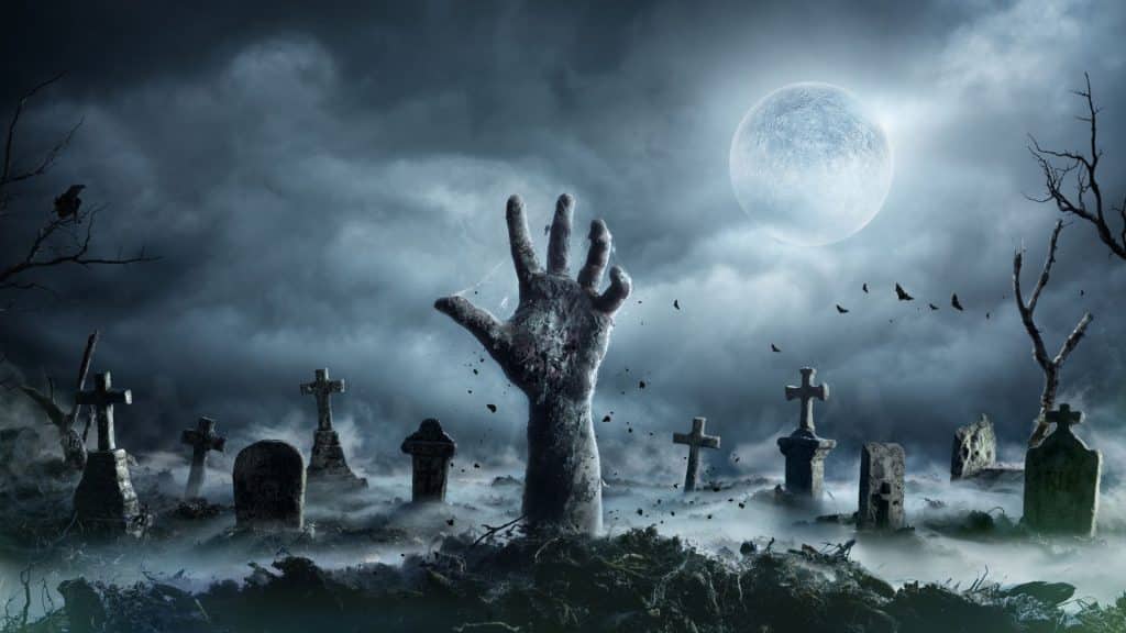 Uma ilustração de um cemitério sombrio em plena lua cheia. Saindo do solo, uma mão de um morto-vivo.