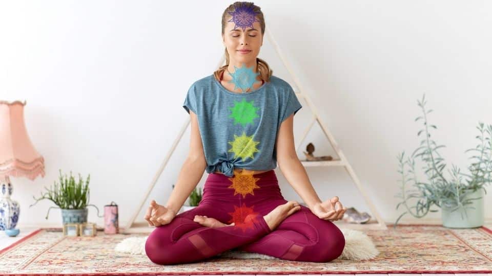 Uma mulher meditando. À frente do corpo dela, pequenos pontos que indicam seu chakra. 