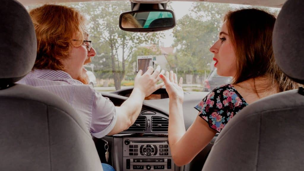 Um casal brigando dentro de um carro.