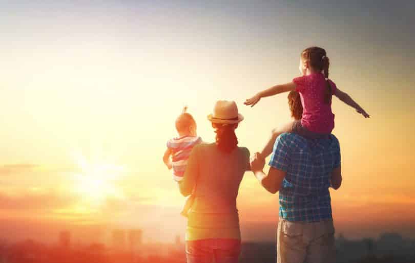 Uma família contemplando um pôr do sol.