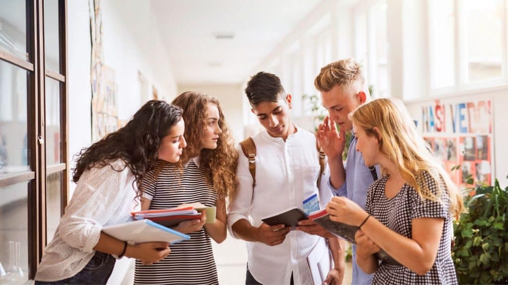 Vários estudantes reunidos num corredor de escola.