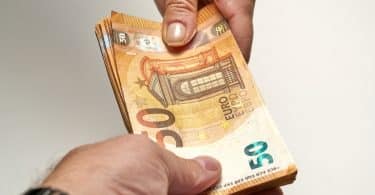 Notas de 50 euros sendo trocadas por pessoas.
