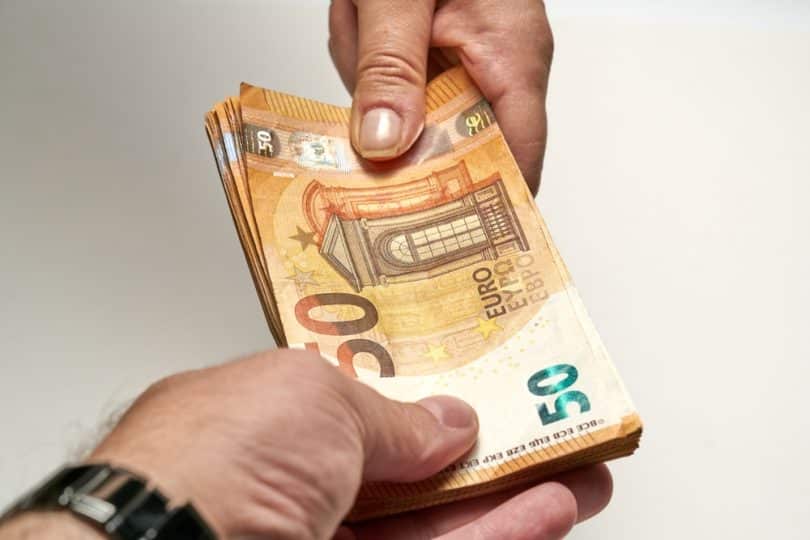 Notas de 50 euros sendo trocadas por pessoas.