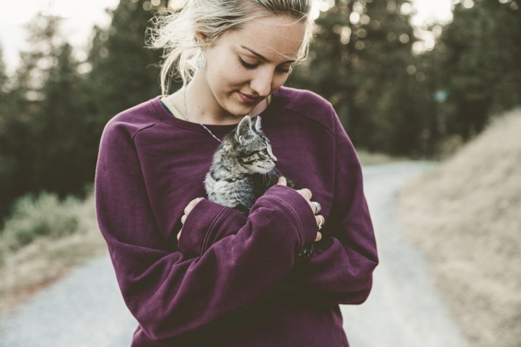 Mulher branca segurando gato.