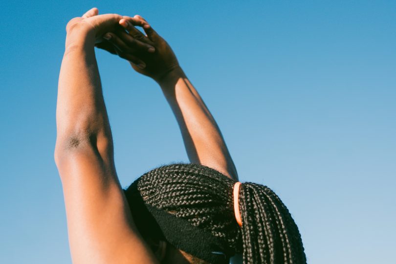 Mulher negra levantando os braços.