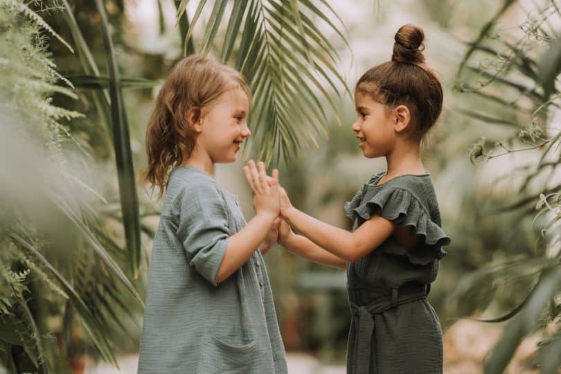 Duas crianças brincando de adoleta.