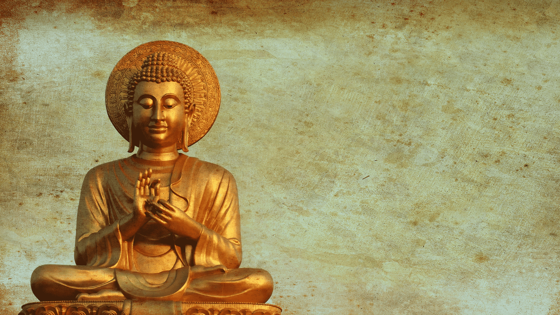 Estátua de ouro de Buda sentado de pernas cruzadas com uma mão na outra