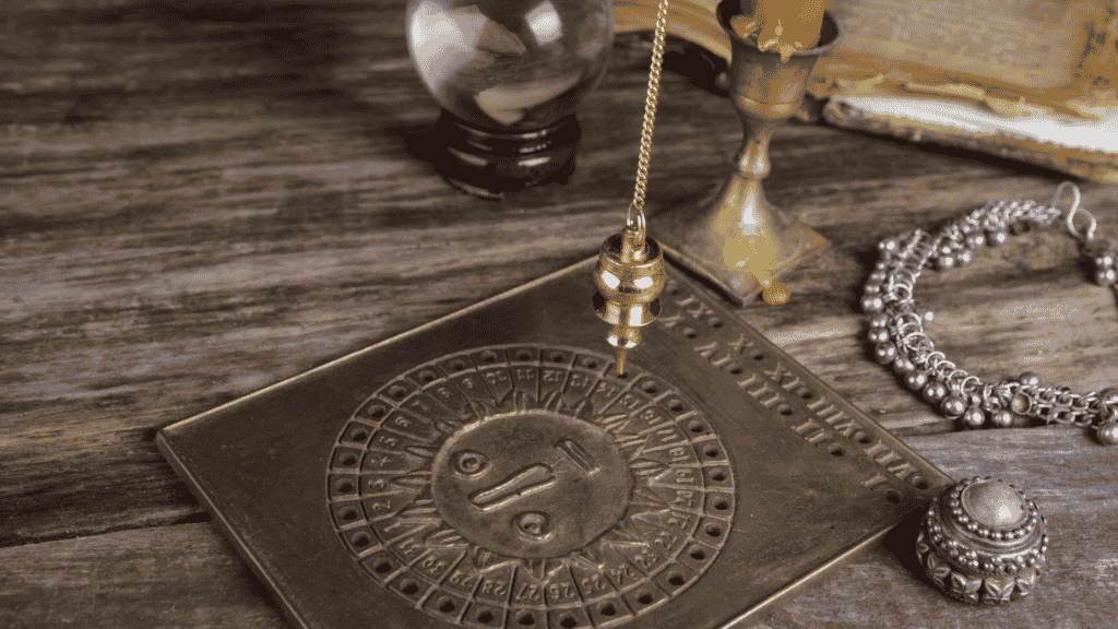 Pêndulo de metal em cima de uma placa de metal ritualística 