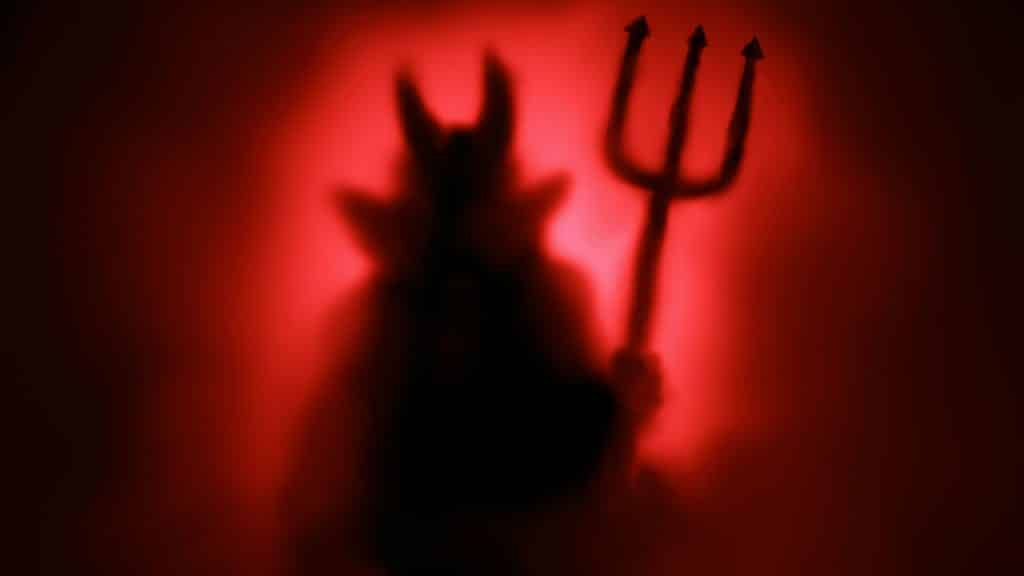 Uma ilustração do diabo bíblico: chifres e um tridente na mão esquerda.
