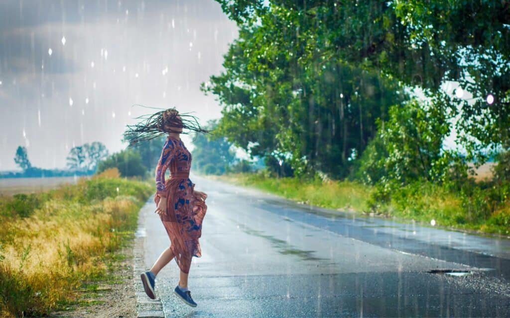 Uma mulher dançando na chuva.