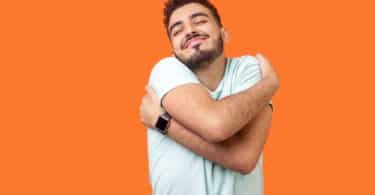 Um homem se abraçando.