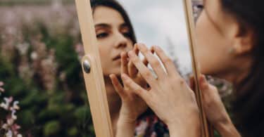Uma mulher se olhando num espelho.