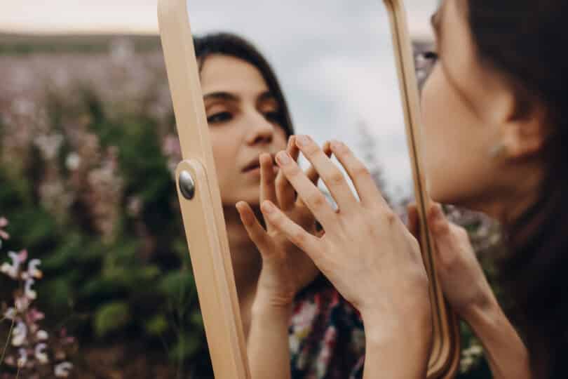 Uma mulher se olhando num espelho.