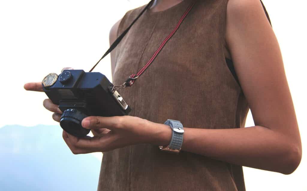 Uma pessoa segurando uma câmera fotográfica.