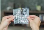 Duas mãos unindo fragmentos de uma mesma fotografia. Cada parte de um fragmento contém um membro de um casal conjugal amoroso.