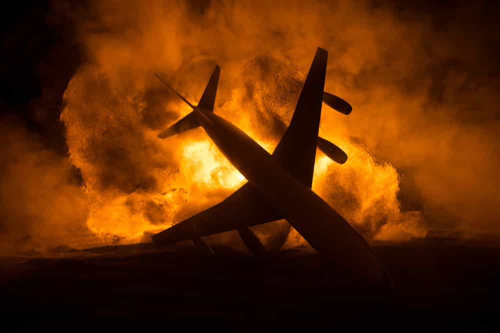 Avião em queda, já entrando em contato com o chão e pegando fogo.