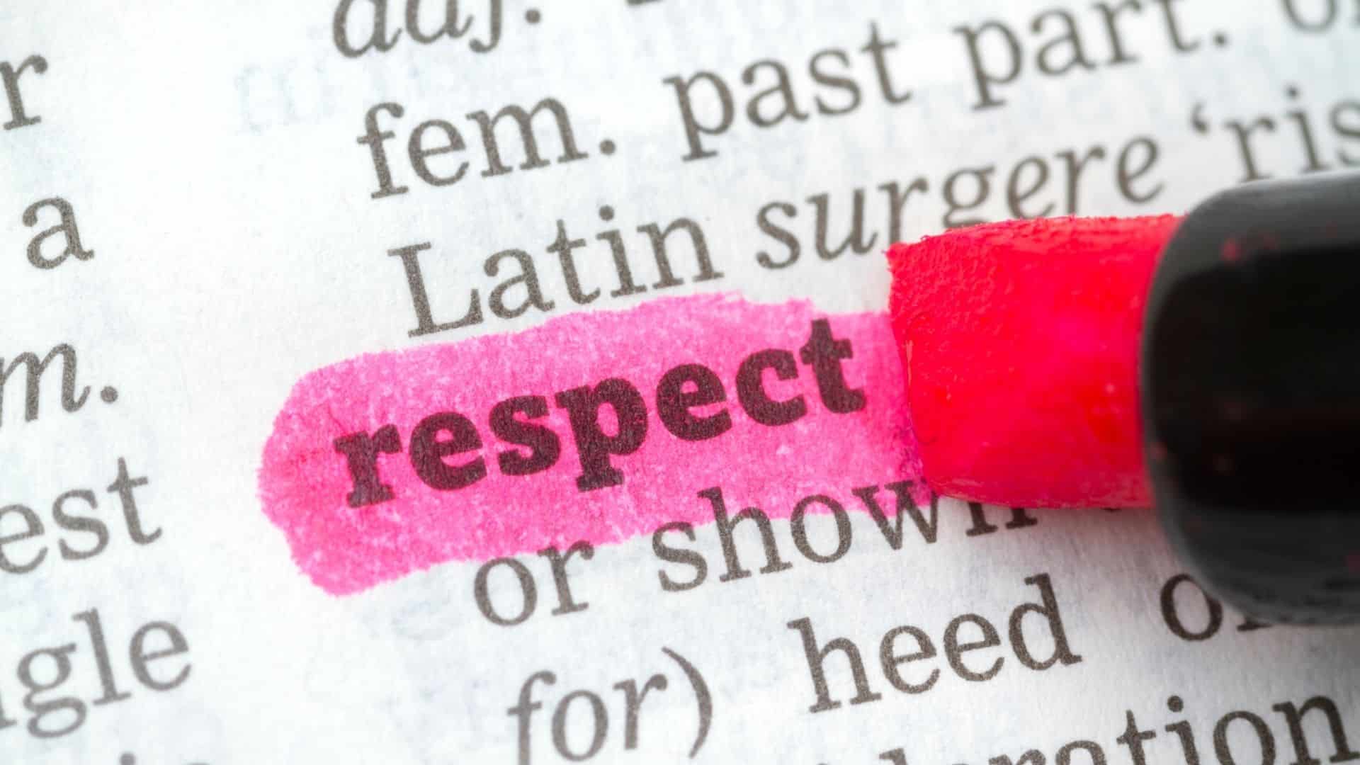Um marca-texto grifando de rosa a palavra respect num livro.