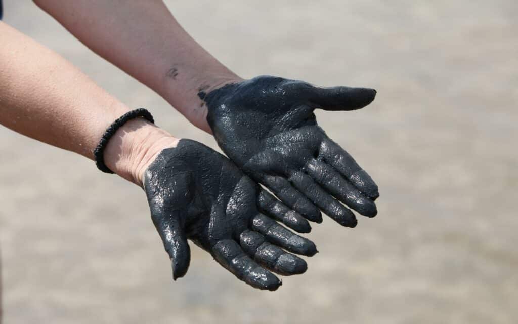 Uma mulher exibindo as mãos dela repletas de lamas