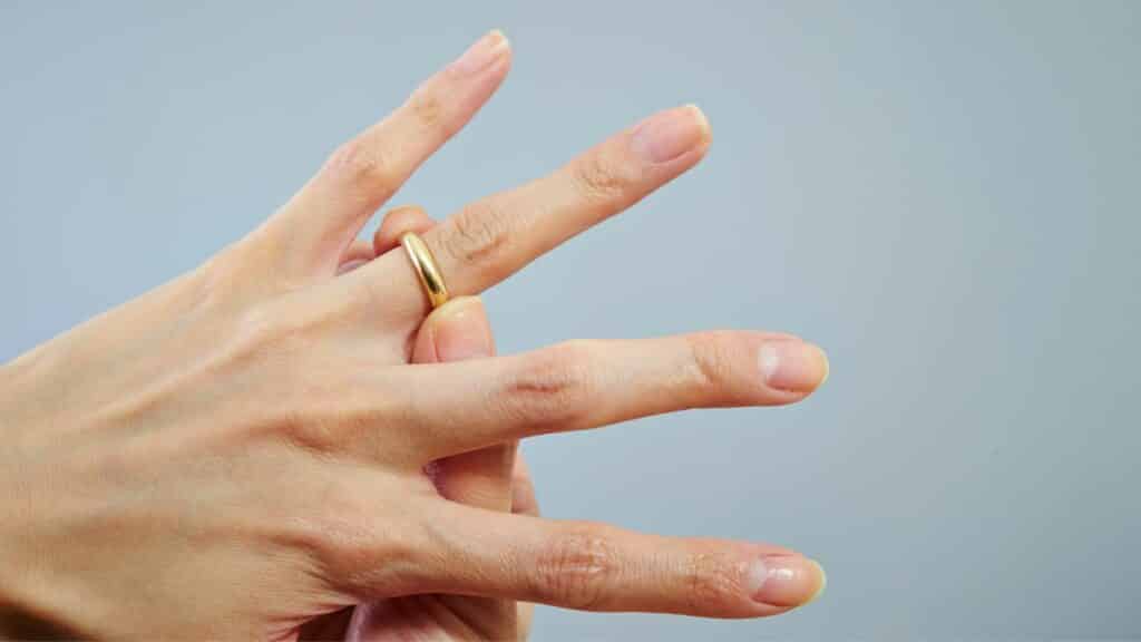 Um anel de ouro num dedo anelar de alguém.
