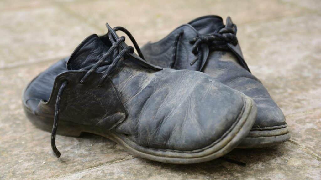 Um par de sapatos pretos danificados.