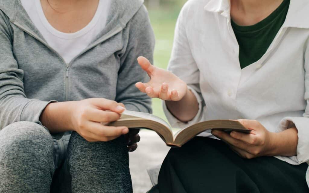 Duas pessoas lendo um livro.