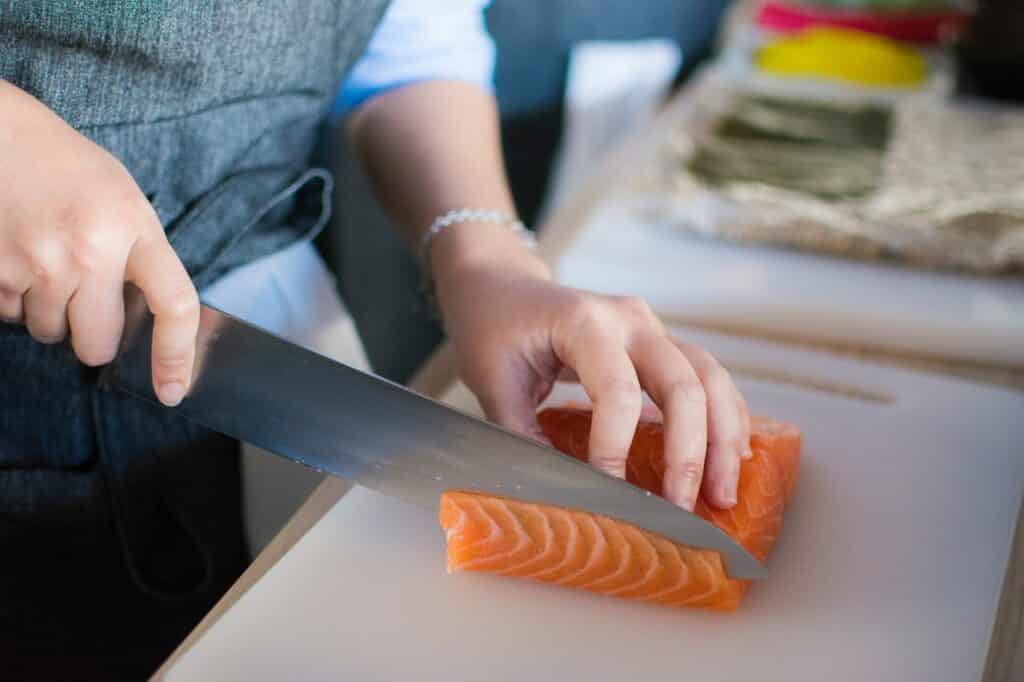 homem cortando um pedaço de carne de salmão