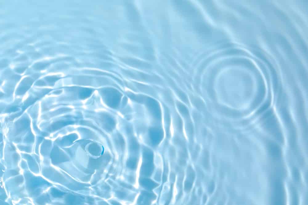 Imagem aproximada de gota de água caindo em monte de água cristalina