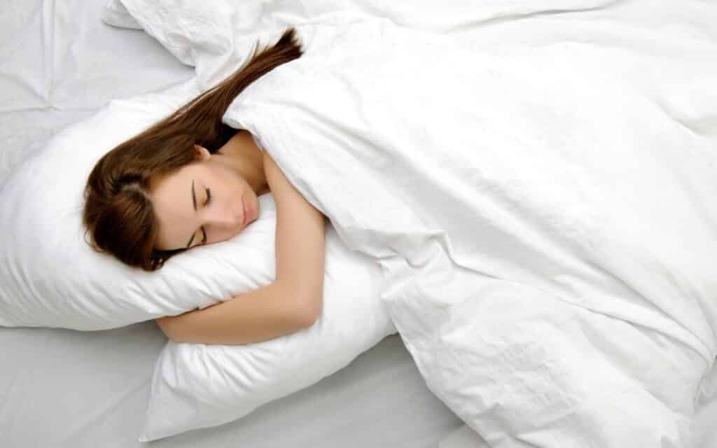 Uma mulher dormindo numa cama.