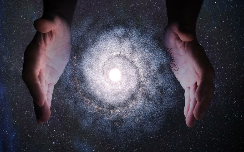 Mãos humanas rodeando uma galáxia.