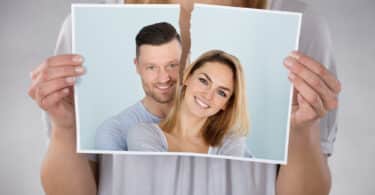 Uma mulher rasgando uma fotografia de um casal.