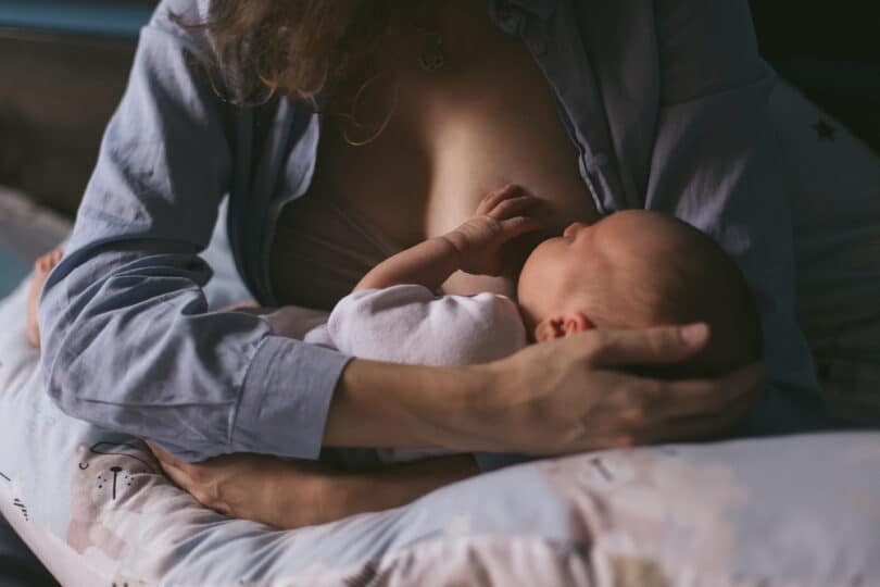 Uma mulher amamentando um bebê.