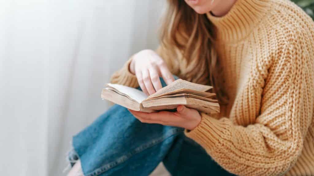 Uma mulher lendo um livro.