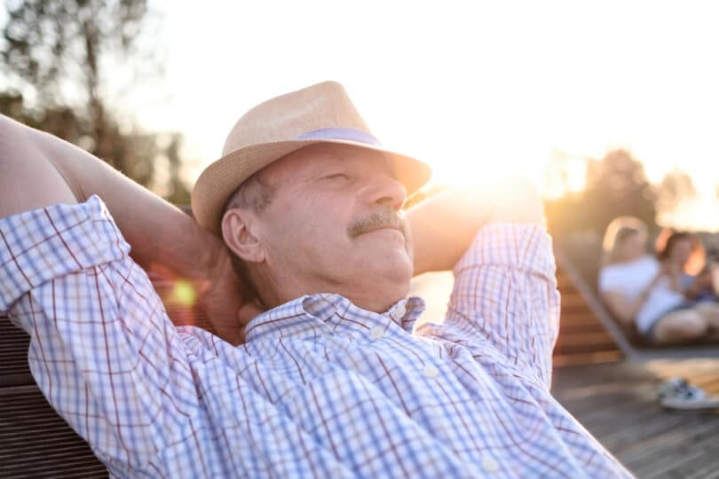 Um homem relaxando sentado numa cadeira.