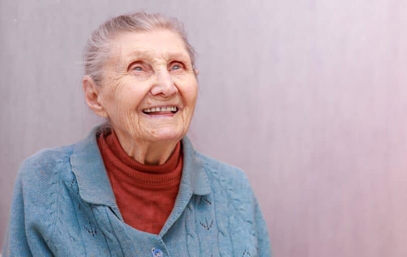 Uma mulher idosa sorrindo.