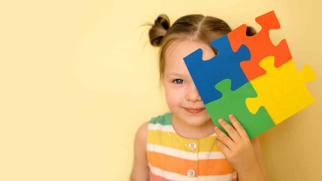 Uma criança autista segurando um quebra-cabeça.