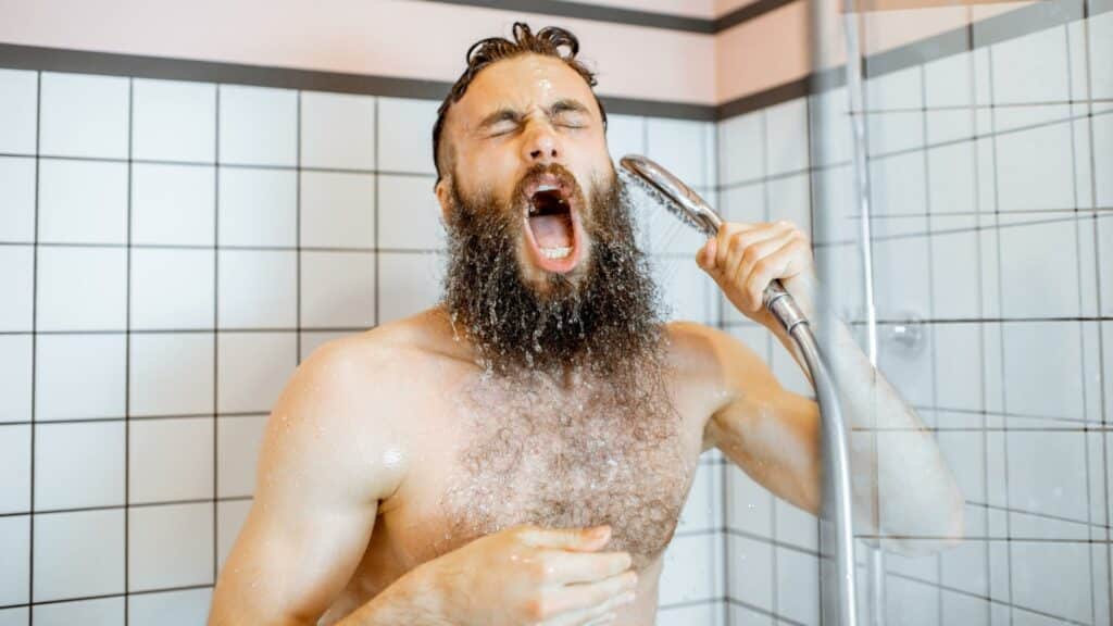 Um homem tomando um banho gelado.